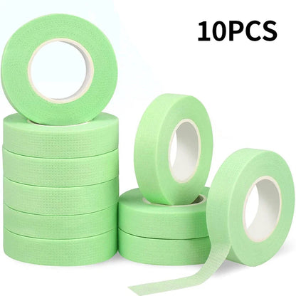 Multiple rolls of colorful micropore eyelash tape for lash extension and lifting, featuring pink, green, white, blue, and purple colors.