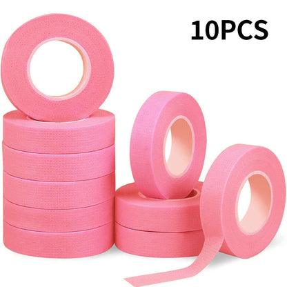 Multiple rolls of colorful micropore eyelash tape for lash extension and lifting, featuring pink, green, white, blue, and purple colors.