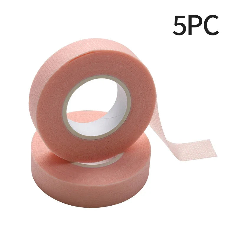 Multiple rolls of colorful micropore eyelash tape for lash extension and lifting, featuring pink, green, white, blue, and purple colors.