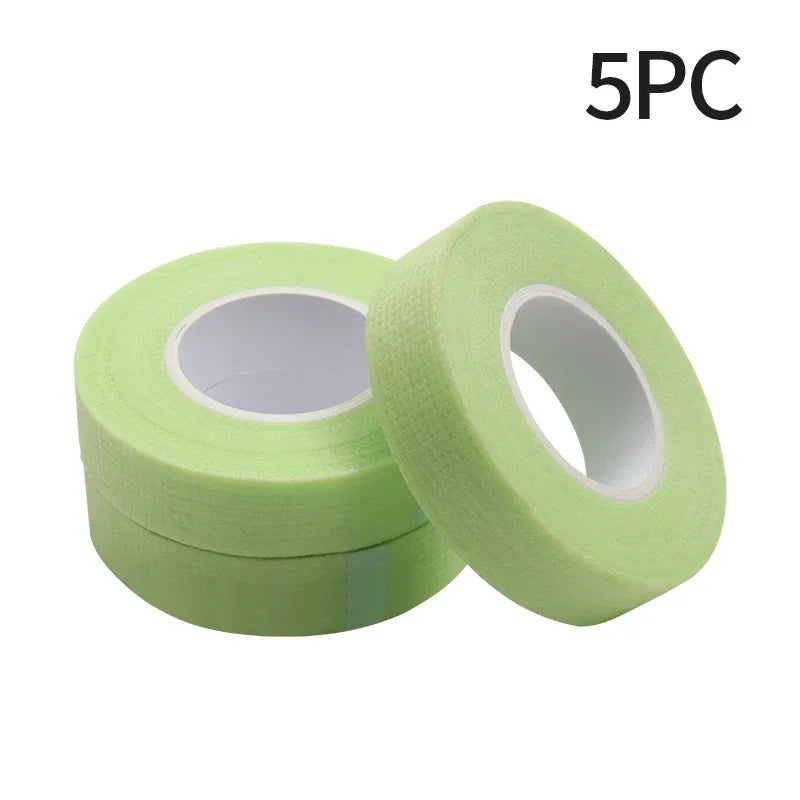 Multiple rolls of colorful micropore eyelash tape for lash extension and lifting, featuring pink, green, white, blue, and purple colors.