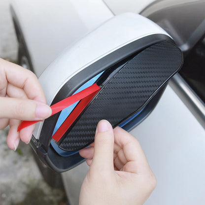 Two carbon fiber-look rain eyebrow visors for car rearview mirrors, providing weather protection and a stylish appearance.