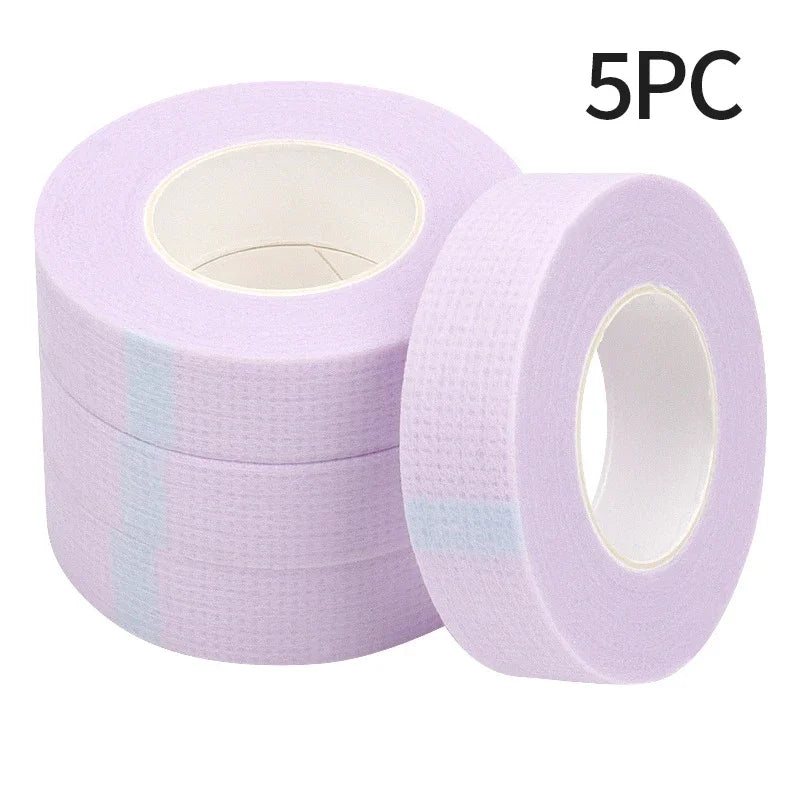 Multiple rolls of colorful micropore eyelash tape for lash extension and lifting, featuring pink, green, white, blue, and purple colors.