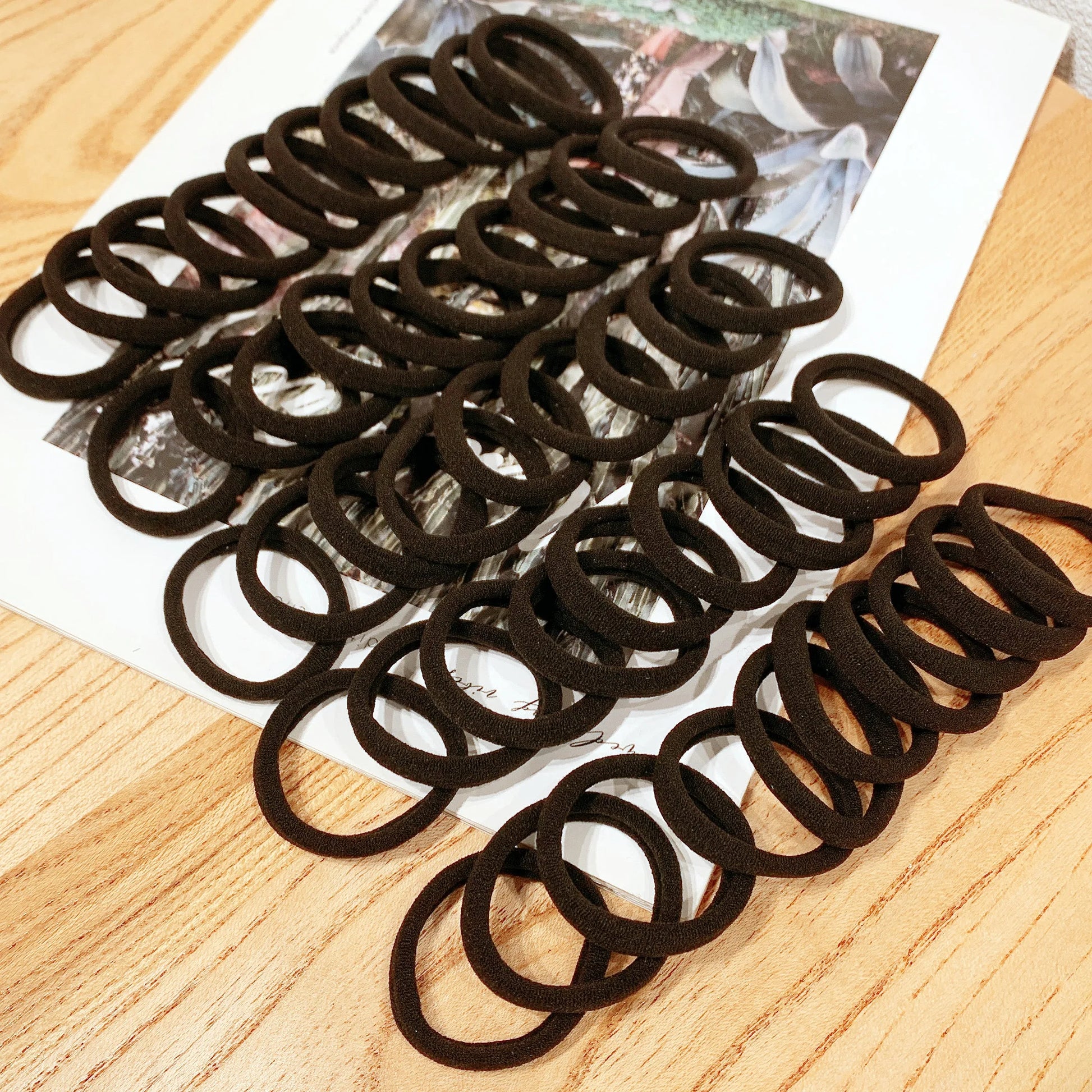 A set of 50/100 black hair bands made of high elastic polyester, perfect for women and girls.