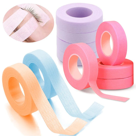 Multiple rolls of colorful micropore eyelash tape for lash extension and lifting, featuring pink, green, white, blue, and purple colors.