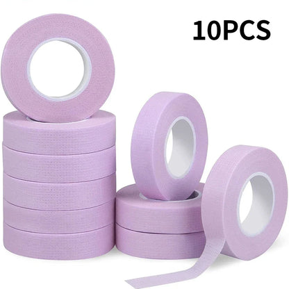 Multiple rolls of colorful micropore eyelash tape for lash extension and lifting, featuring pink, green, white, blue, and purple colors.