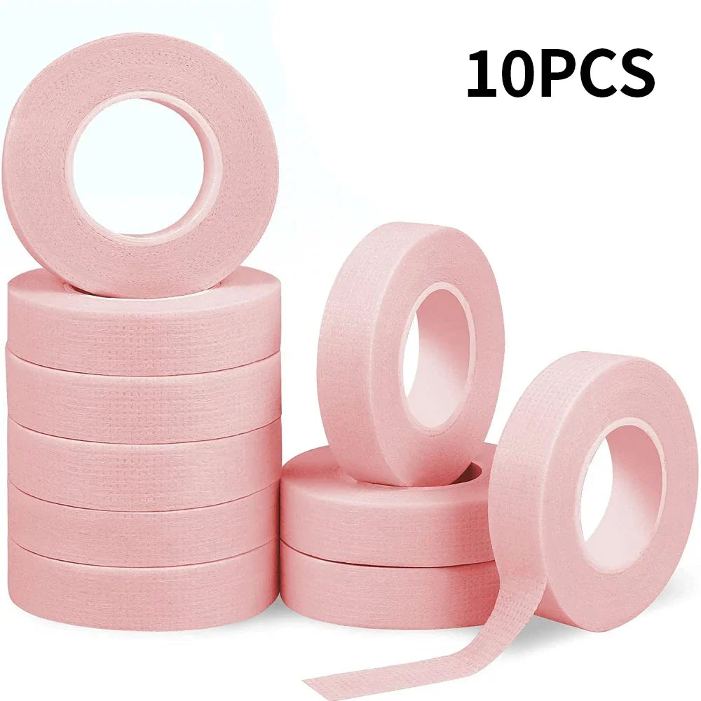 Multiple rolls of colorful micropore eyelash tape for lash extension and lifting, featuring pink, green, white, blue, and purple colors.