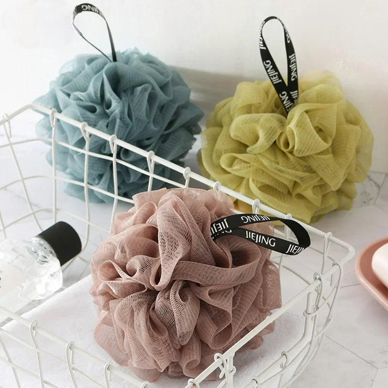 Soft mesh bath sponge ball in assorted colors for exfoliating and cleansing during showers.