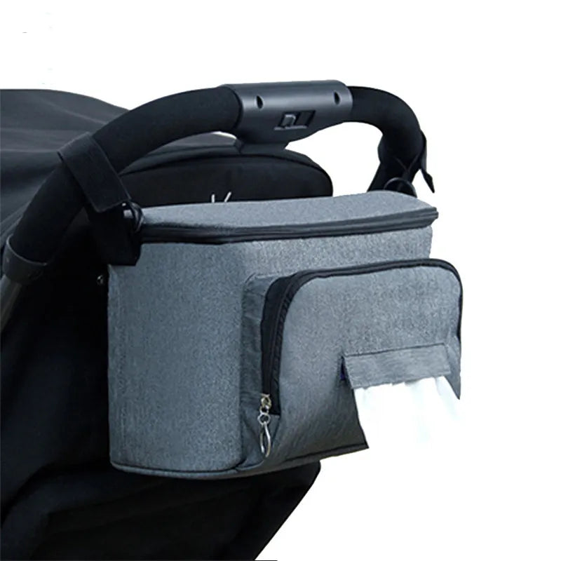 Waterproof denim diaper bag with large capacity, adjustable straps, and insulated drink holders, attached to a stroller.