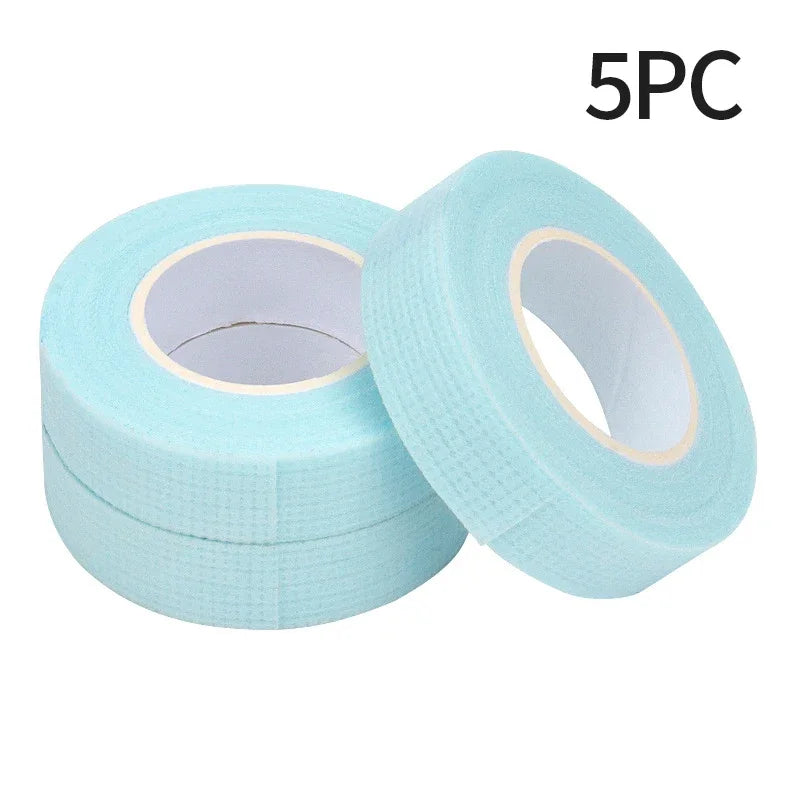 Multiple rolls of colorful micropore eyelash tape for lash extension and lifting, featuring pink, green, white, blue, and purple colors.